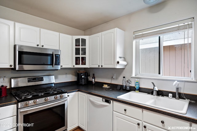 1957 Terrebonne Loop, Anchorage, AK 99502 - kitchen with appliances with stainless steel finishes, dark countertops, white cabinets, and glass insert cabinets
