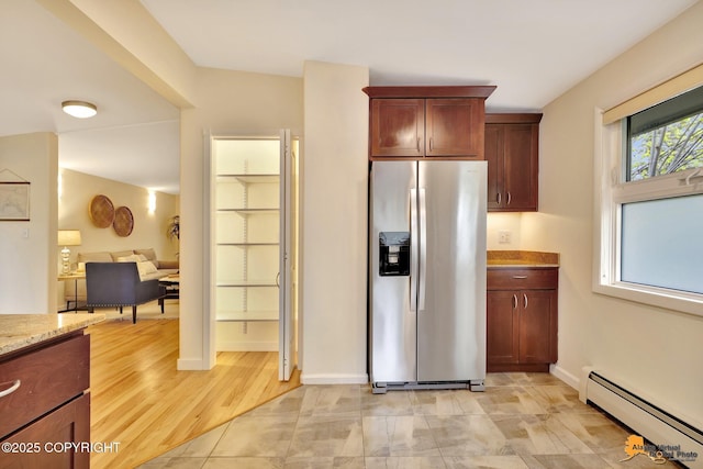 kitchen featuring stainless steel refrigerator with ice dispenser, a baseboard radiator, light stone counters, and baseboards