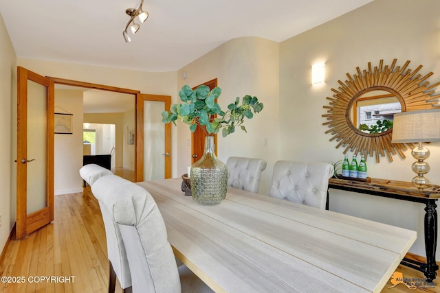 dining room with hardwood / wood-style flooring and rail lighting