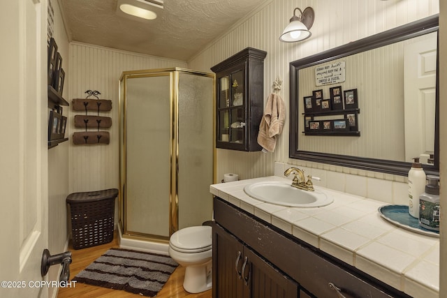 1061 E Agate Ln, Wasilla, AK 99654 - full bath with toilet, a shower stall, vanity, wood finished floors, and a textured ceiling