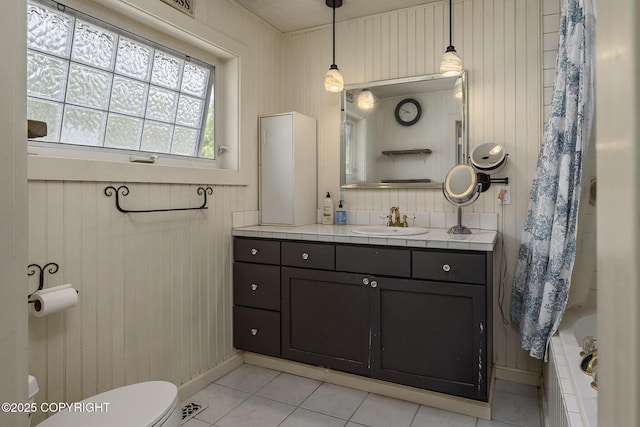 1061 E Agate Ln, Wasilla, AK 99654 - bathroom featuring toilet, vanity, baseboards, tile patterned flooring, and wood walls