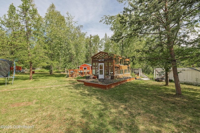 1061 E Agate Ln, Wasilla, AK 99654 - view of grassy yard featuring a trampoline and an outdoor structure