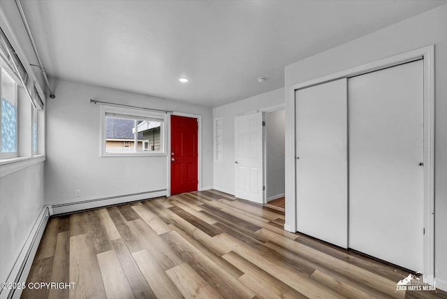 4313 Lois Dr, Anchorage, AK 99517 - unfurnished bedroom with a baseboard heating unit, wood finished floors, a closet, recessed lighting, and baseboards