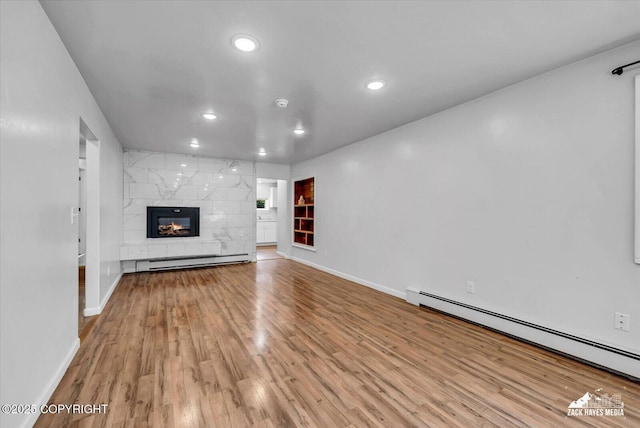 4313 Lois Dr, Anchorage, AK 99517 - unfurnished living room featuring baseboard heating, baseboards, wood finished floors, and recessed lighting