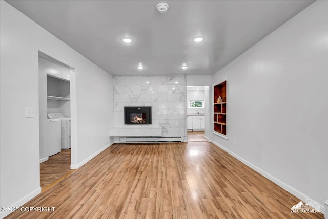 4313 Lois Dr, Anchorage, AK 99517 - unfurnished living room featuring separate washer and dryer, built in shelves, baseboard heating, baseboards, and recessed lighting