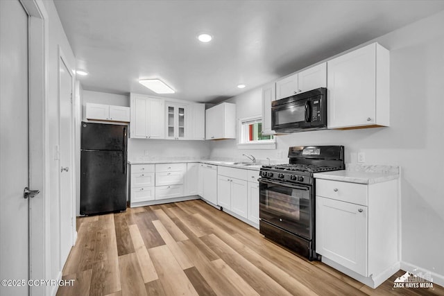 4313 Lois Dr, Anchorage, AK 99517 - kitchen with black appliances, light countertops, white cabinetry, light wood finished floors, and recessed lighting