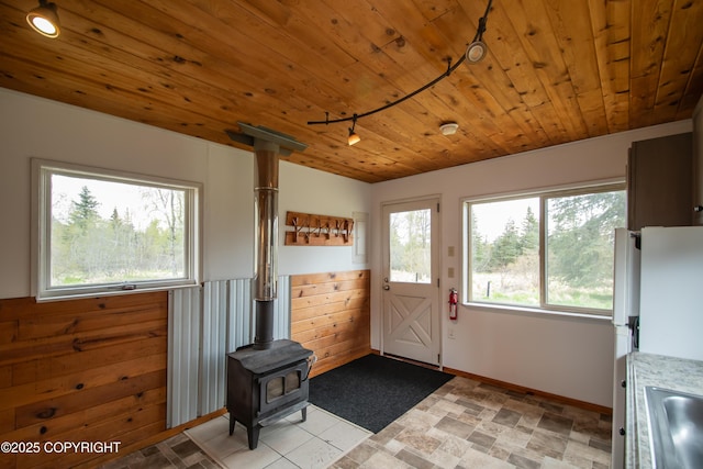55851 Glenn Rd, Homer, AK 99603 - doorway featuring a wood stove, wooden ceiling, and baseboards