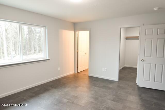 41485 Derks Lake Rd, Soldotna, AK 99669 - unfurnished bedroom with a closet, baseboards, and a walk in closet