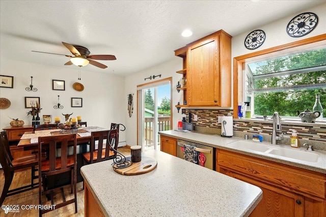 664 E Auklet Ave, Palmer, AK 99645 - kitchen featuring dishwasher, decorative backsplash, a sink, brown cabinets, and light countertops
