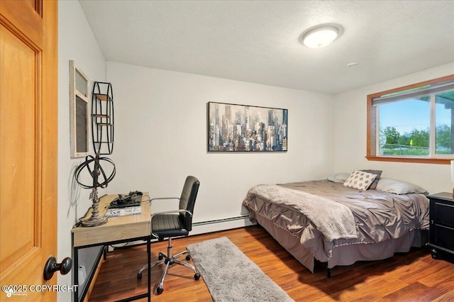 664 E Auklet Ave, Palmer, AK 99645 - bedroom featuring wood finished floors, a baseboard radiator, a desk, and a textured ceiling