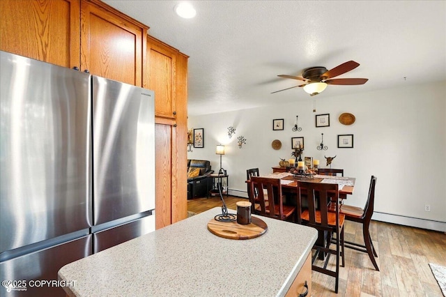664 E Auklet Ave, Palmer, AK 99645 - dining room featuring ceiling fan, baseboard heating, and light wood-type flooring