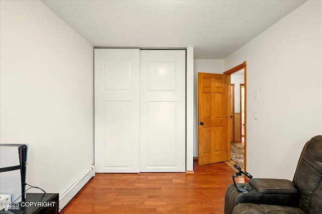 664 E Auklet Ave, Palmer, AK 99645 - living area featuring baseboard heating, wood finished floors, and a textured ceiling