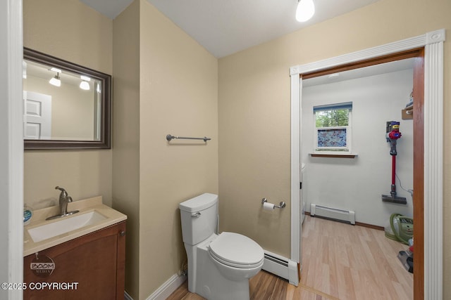 9224 Geese Cir, Eagle River, AK 99577 - bathroom with a baseboard heating unit, wood finished floors, toilet, and vanity