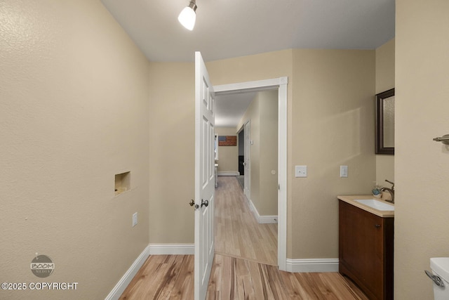 9224 Geese Cir, Eagle River, AK 99577 - hallway with a sink, light wood finished floors, and baseboards