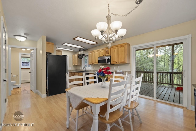 9224 Geese Cir, Eagle River, AK 99577 - dining area featuring light wood finished floors, a chandelier, a baseboard heating unit, and baseboards