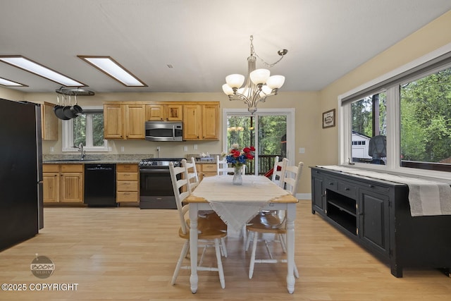 9224 Geese Cir, Eagle River, AK 99577 - kitchen with stainless steel appliances, light wood finished floors, a chandelier, and decorative light fixtures