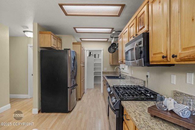 9224 Geese Cir, Eagle River, AK 99577 - kitchen with appliances with stainless steel finishes, a sink, light wood-style flooring, and light stone countertops