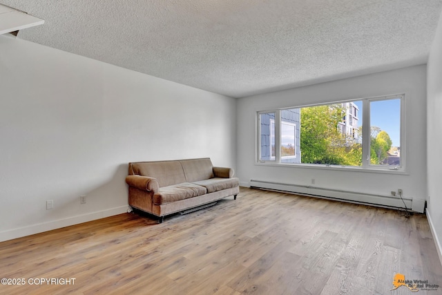 832 O Pl Unit 832, Anchorage, AK 99501 - living area featuring a baseboard radiator, a textured ceiling, wood finished floors, and baseboards