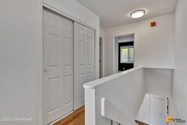 832 O Pl Unit 832, Anchorage, AK 99501 - hall with an upstairs landing, a textured ceiling, and light wood-type flooring