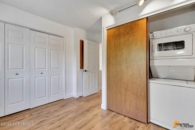 832 O Pl Unit 832, Anchorage, AK 99501 - kitchen featuring stacked washer and clothes dryer, light wood-type flooring, and a textured ceiling