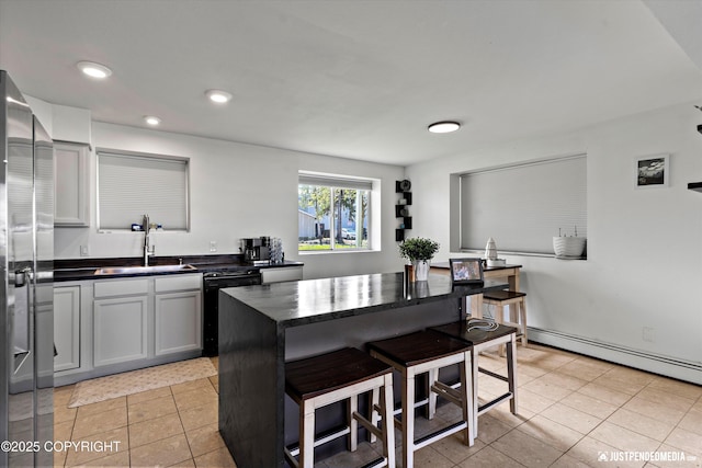 437 E 14th Ave, Anchorage, AK 99501 - kitchen featuring dishwashing machine, a sink, dark countertops, a kitchen bar, and stainless steel refrigerator with ice dispenser