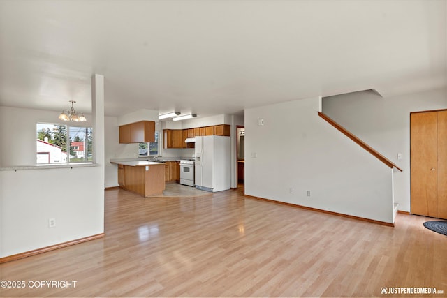 437 E 14th Ave, Anchorage, AK 99501 - unfurnished living room featuring light wood-style flooring, a chandelier, baseboards, and stairway