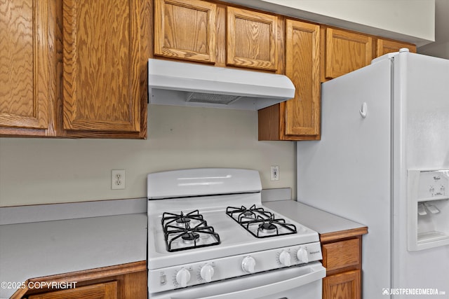 437 E 14th Ave, Anchorage, AK 99501 - kitchen featuring under cabinet range hood, white appliances, light countertops, and brown cabinets