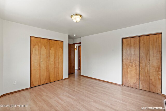 437 E 14th Ave, Anchorage, AK 99501 - unfurnished bedroom with light wood-style floors, baseboards, and multiple closets