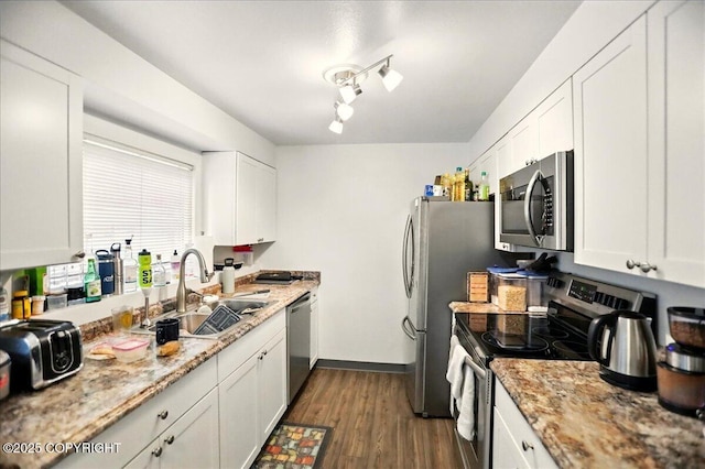 4109 Garfield St, Anchorage, AK 99503 - kitchen with stainless steel appliances, a sink, white cabinetry, dark wood-style floors, and light stone countertops
