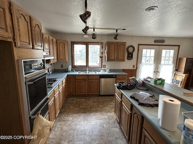315 On Par Ln, Soldotna, AK 99669 - kitchen featuring stainless steel appliances, wallpapered walls, french doors, a sink, and under cabinet range hood