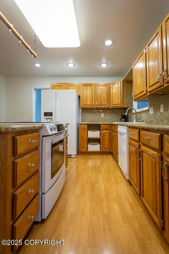 19404 Middleton Loop, Eagle River, AK 99577 - kitchen with white appliances, a sink, light wood-style floors, brown cabinetry, and recessed lighting