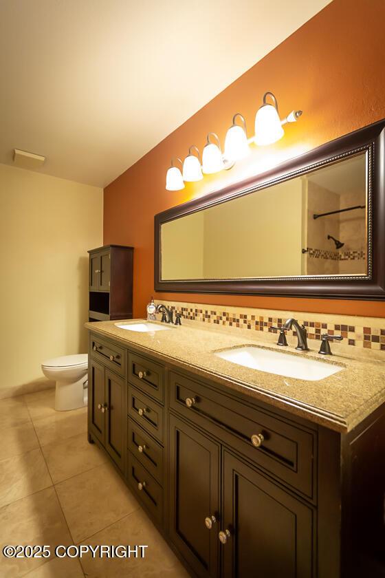 19404 Middleton Loop, Eagle River, AK 99577 - bathroom with tile patterned flooring, toilet, double vanity, and tasteful backsplash