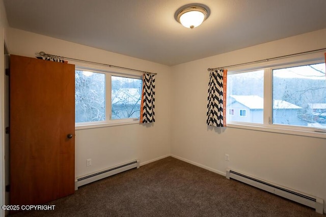19404 Middleton Loop, Eagle River, AK 99577 - spare room featuring a baseboard heating unit, dark carpet, and baseboards