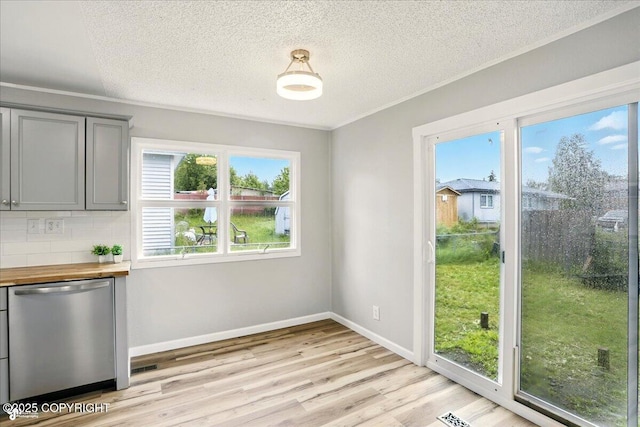 3624 E 16th Ave, Anchorage, AK 99508 - unfurnished dining area with plenty of natural light, light wood finished floors, a textured ceiling, and baseboards