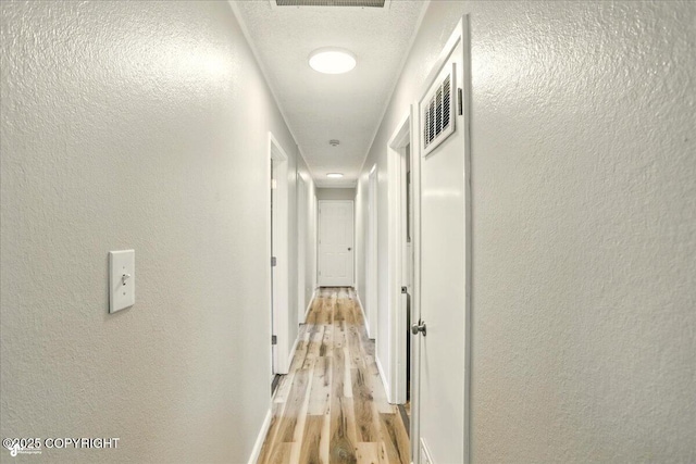 3624 E 16th Ave, Anchorage, AK 99508 - corridor with light wood-style flooring and a textured wall
