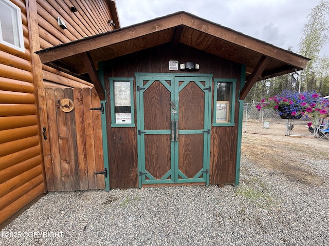 view of outdoor structure with an outbuilding and fence