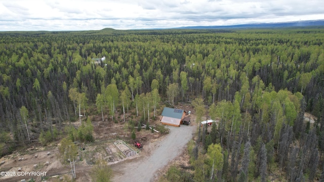 aerial view of property and surrounding area featuring a heavily wooded area