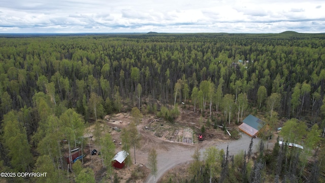 aerial view of property's location featuring a forest