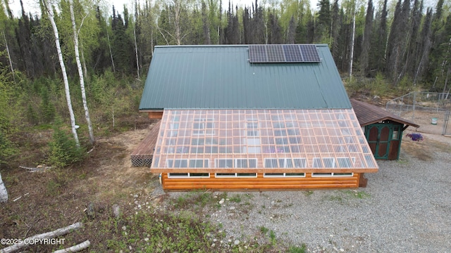 view of outdoor structure with a forest view and solar panels