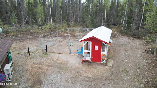 view of poultry coop with a wooded view and fence
