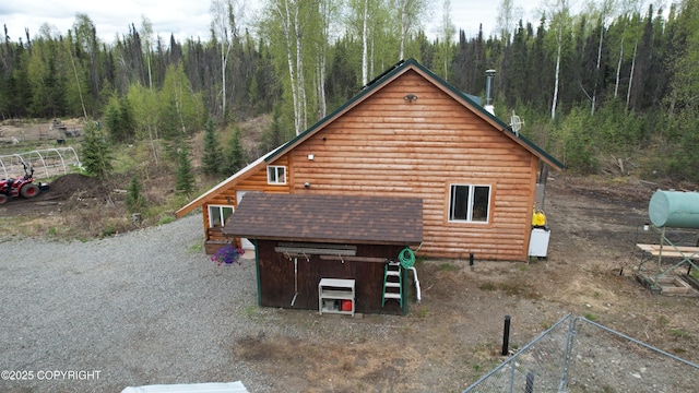 view of property exterior featuring a view of trees