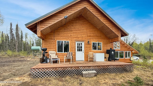rear view of house featuring a wooden deck and heating fuel