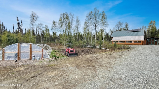 view of yard featuring a greenhouse and an outdoor structure