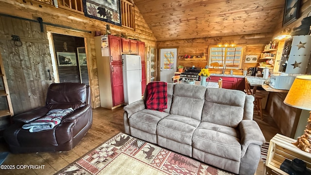 living room featuring lofted ceiling, wood walls, wooden ceiling, wood finished floors, and a barn door