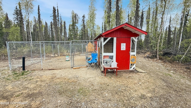 view of poultry coop with fence and a view of trees