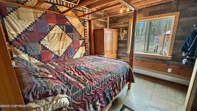 bedroom with a baseboard radiator, wooden walls, and hardwood / wood-style floors