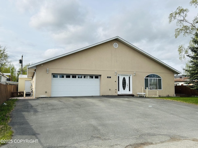 8330 E 5th Ave, Anchorage, AK 99504 - view of front of home featuring driveway, a garage, and stucco siding