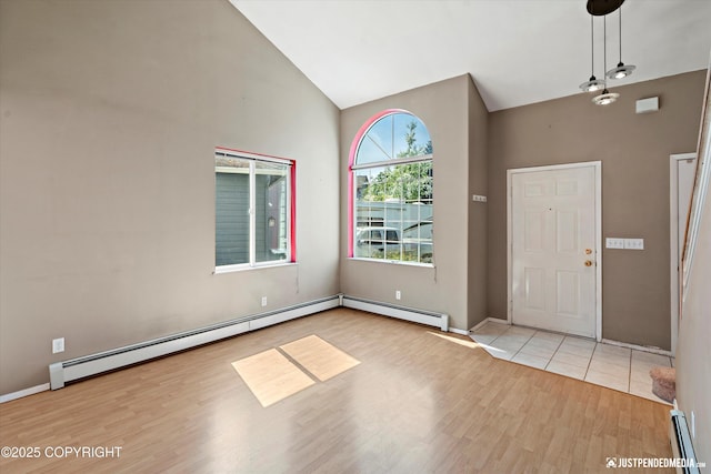 10321 Compass Cir, Anchorage, AK 99515 - foyer with wood finished floors, a baseboard heating unit, baseboards, and high vaulted ceiling