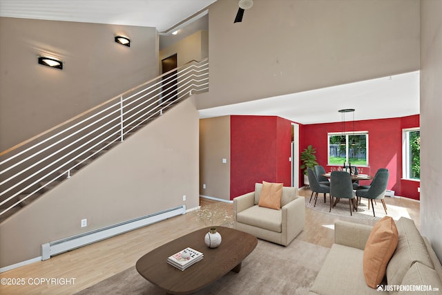 10321 Compass Cir, Anchorage, AK 99515 - living area with a baseboard heating unit, wood finished floors, baseboards, and a high ceiling