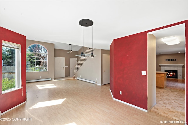 10321 Compass Cir, Anchorage, AK 99515 - unfurnished living room with a baseboard radiator, a baseboard heating unit, healthy amount of natural light, and light wood-style flooring